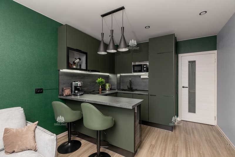 темно-зеленая кухня с серой столешницей и фартуком